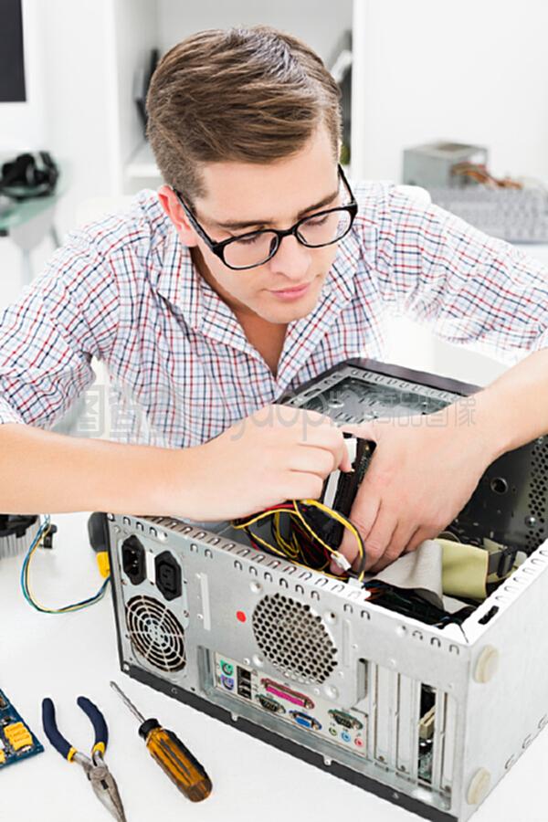 在坏电脑上工作的年轻技术员